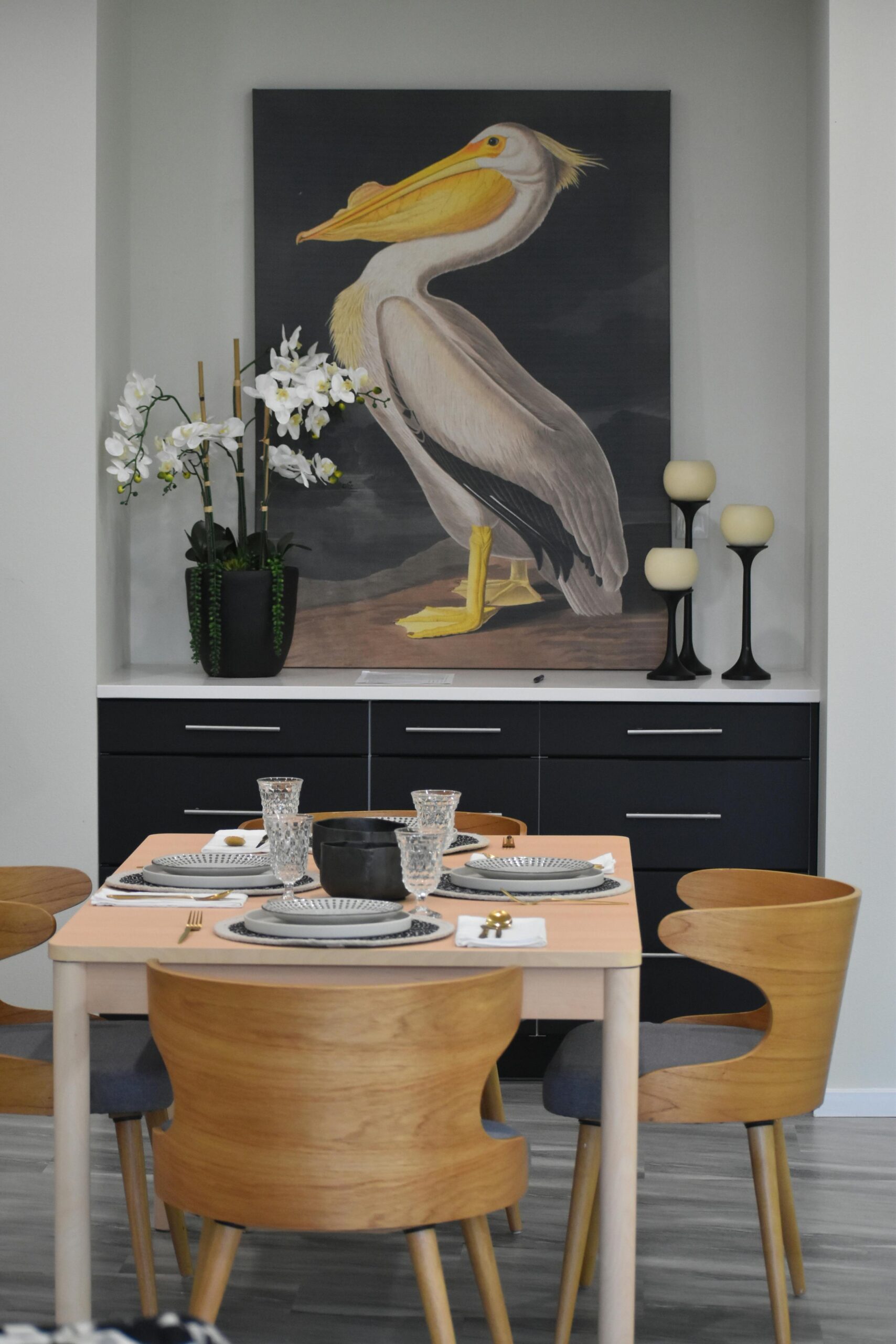 Contemporary dining area featuring a pelican painting and elegant table setting.